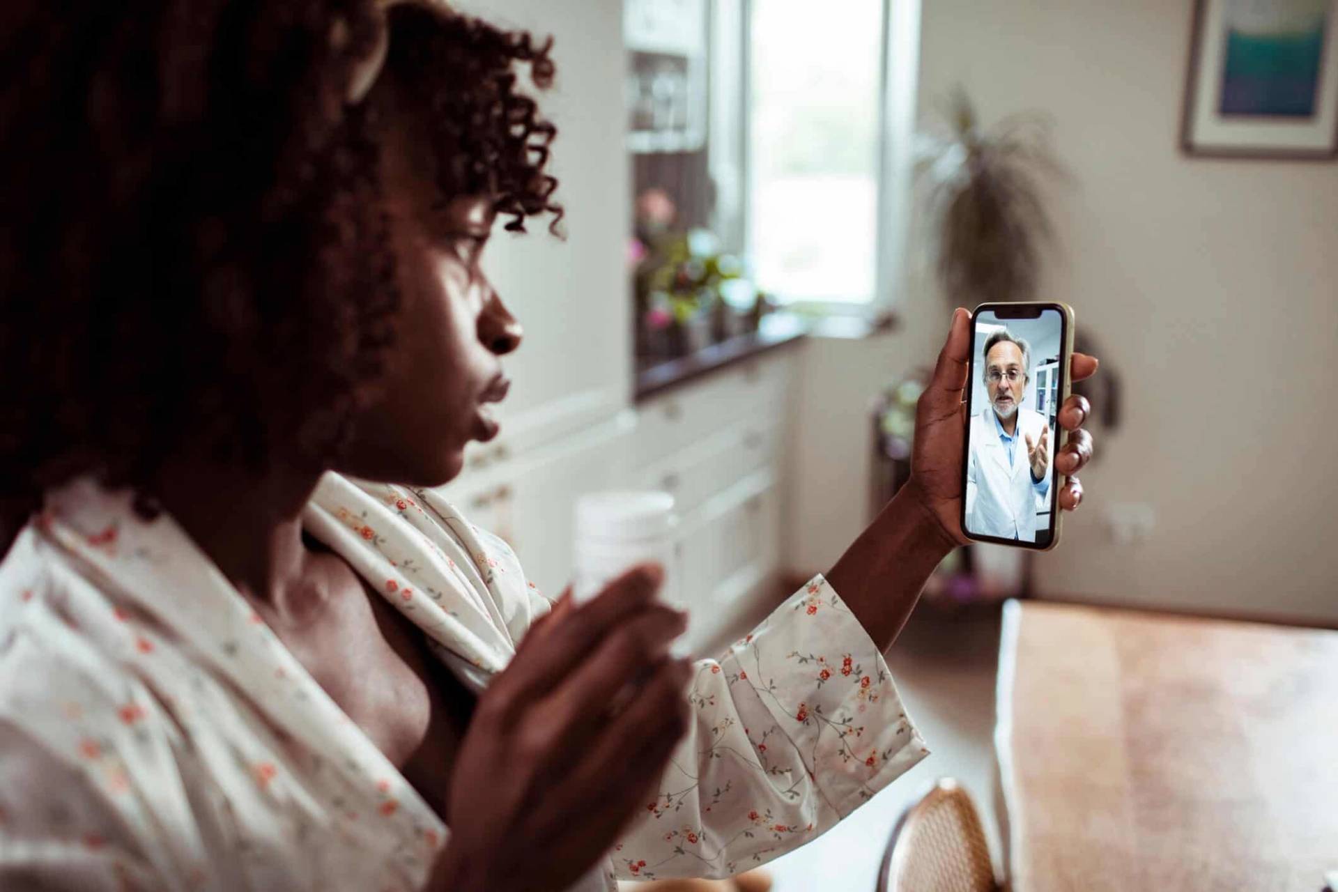 Femme échangeant en vidéo avec un professionnel sur son téléphone.