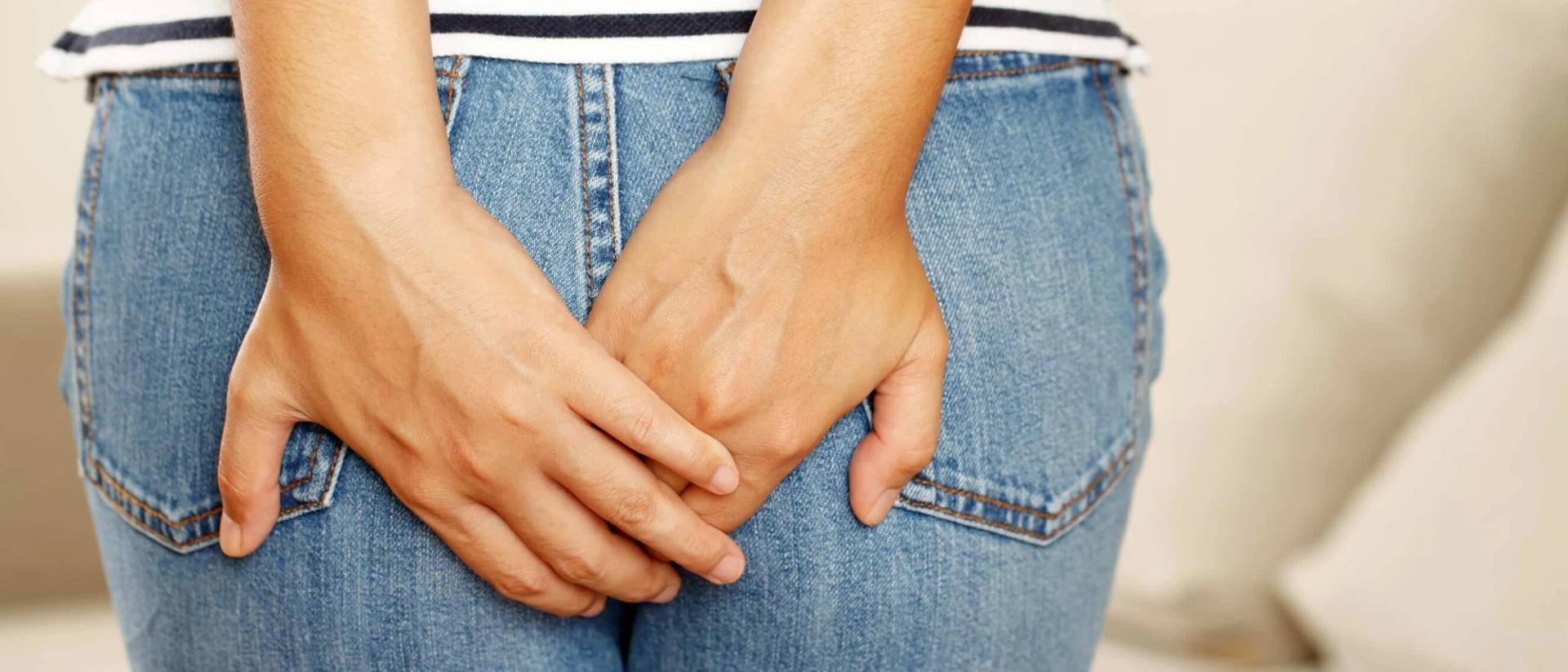 Personne posant ses mains sur les fesses, par-dessus un jean.