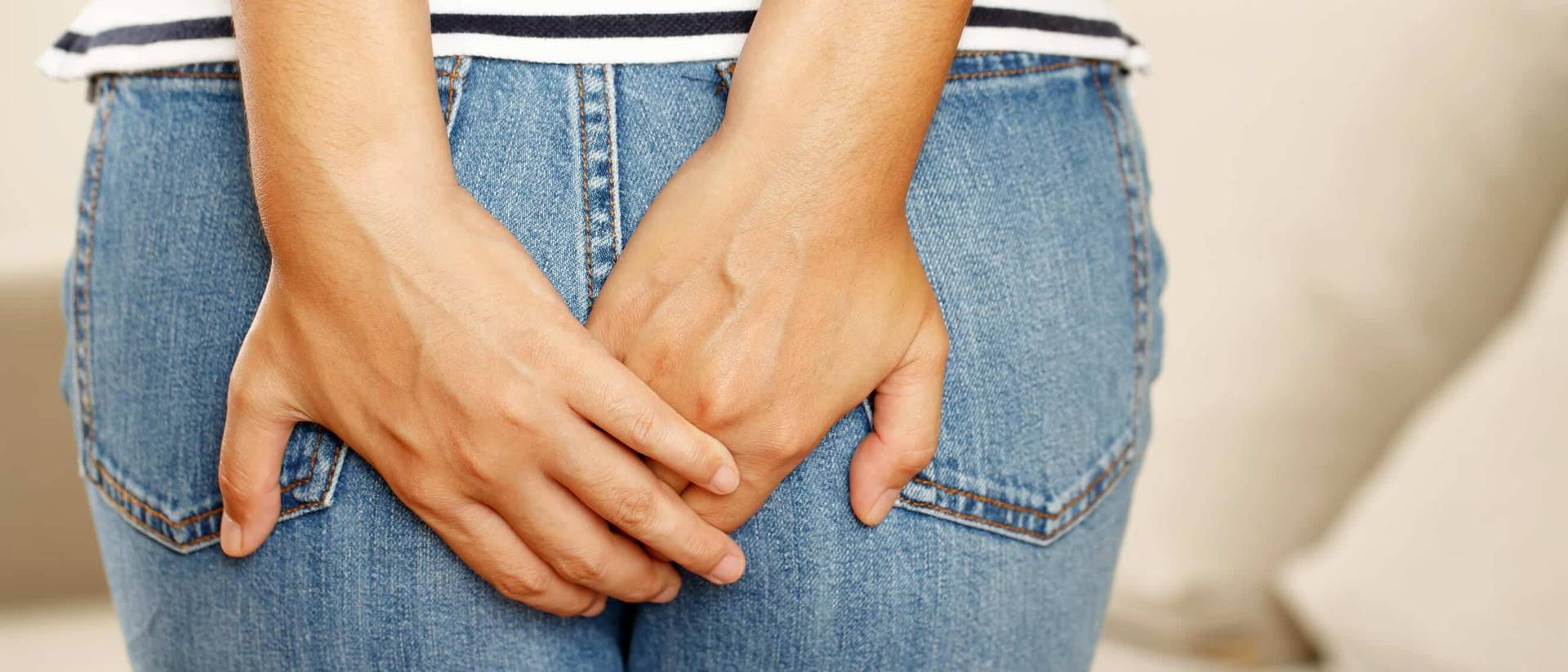 Personne posant ses mains sur les fesses, par-dessus un jean.