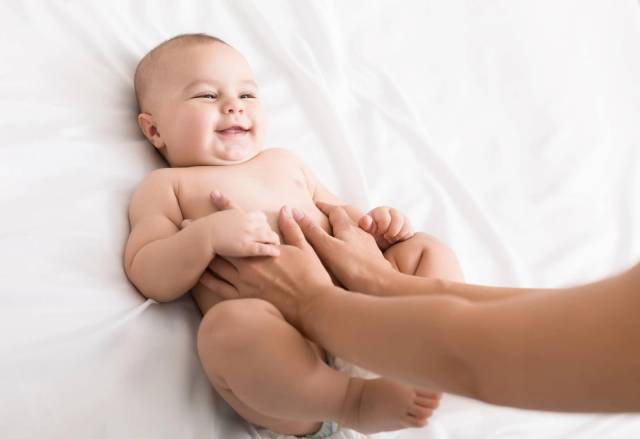 Bébé sur le dos tenue par sa mère