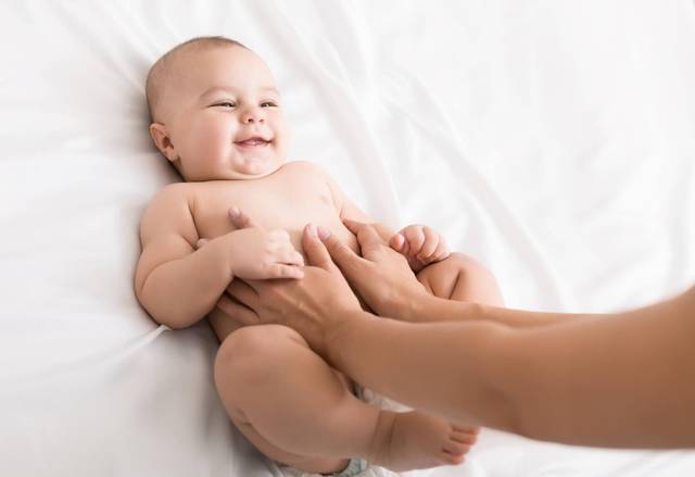 Bébé sur le dos tenue par sa mère
