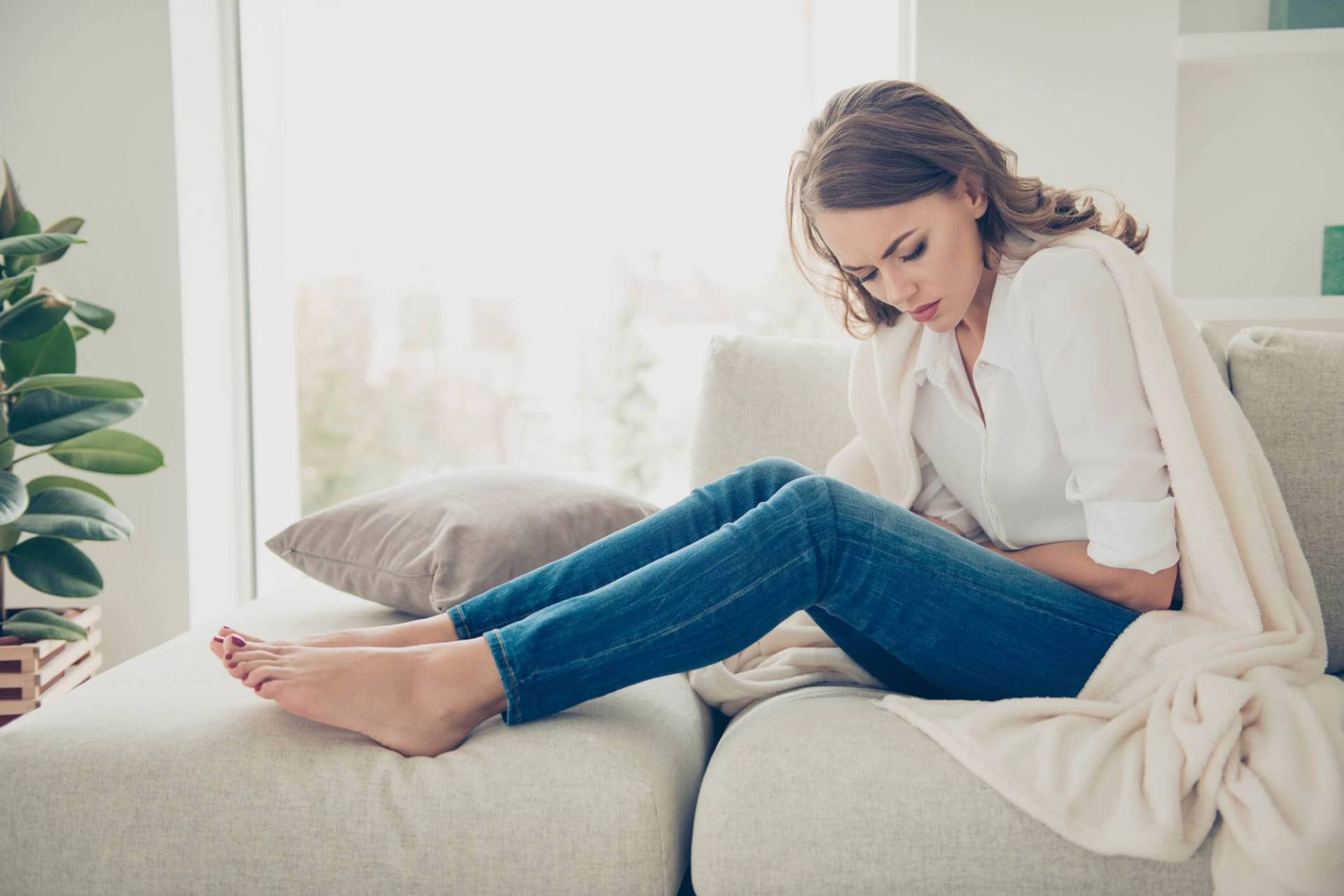 Femme assise, penchée vers son ventre.