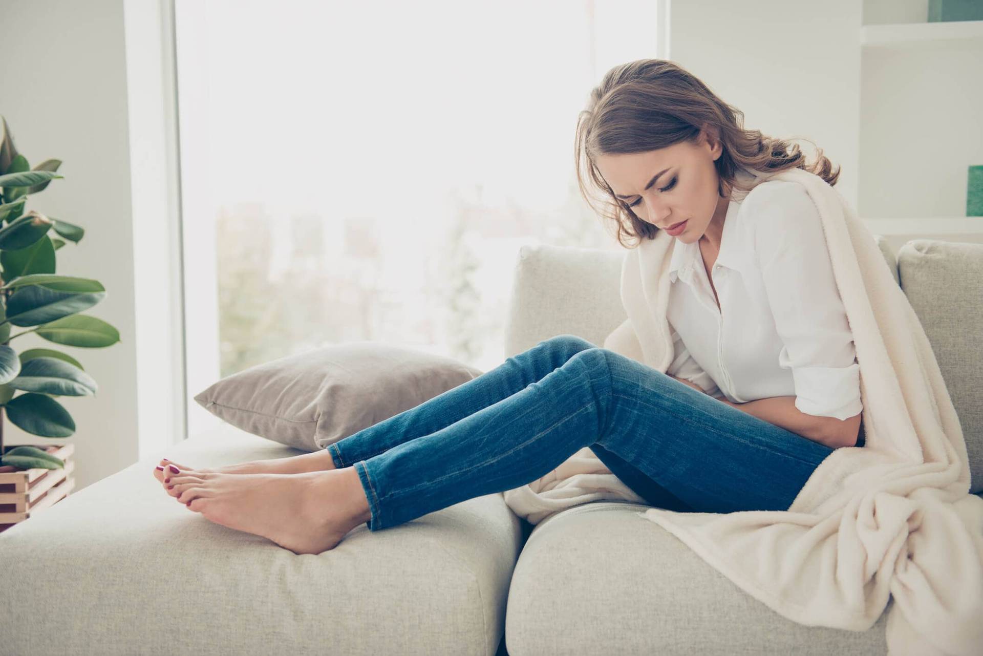 Femme assise, penchée vers son ventre.