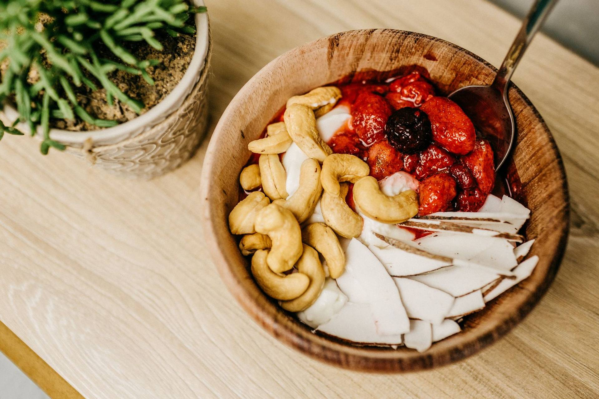 Bol de fruits rouges, de noix de cajou et de lamelles de noix de coco.