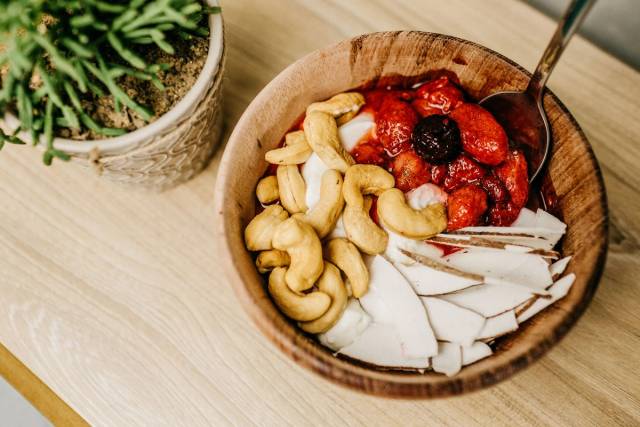 Bol de fruits rouges, de noix de cajou et de lamelles de noix de coco.