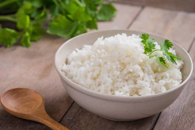 Bol de riz blanc posé sur une table en bois.