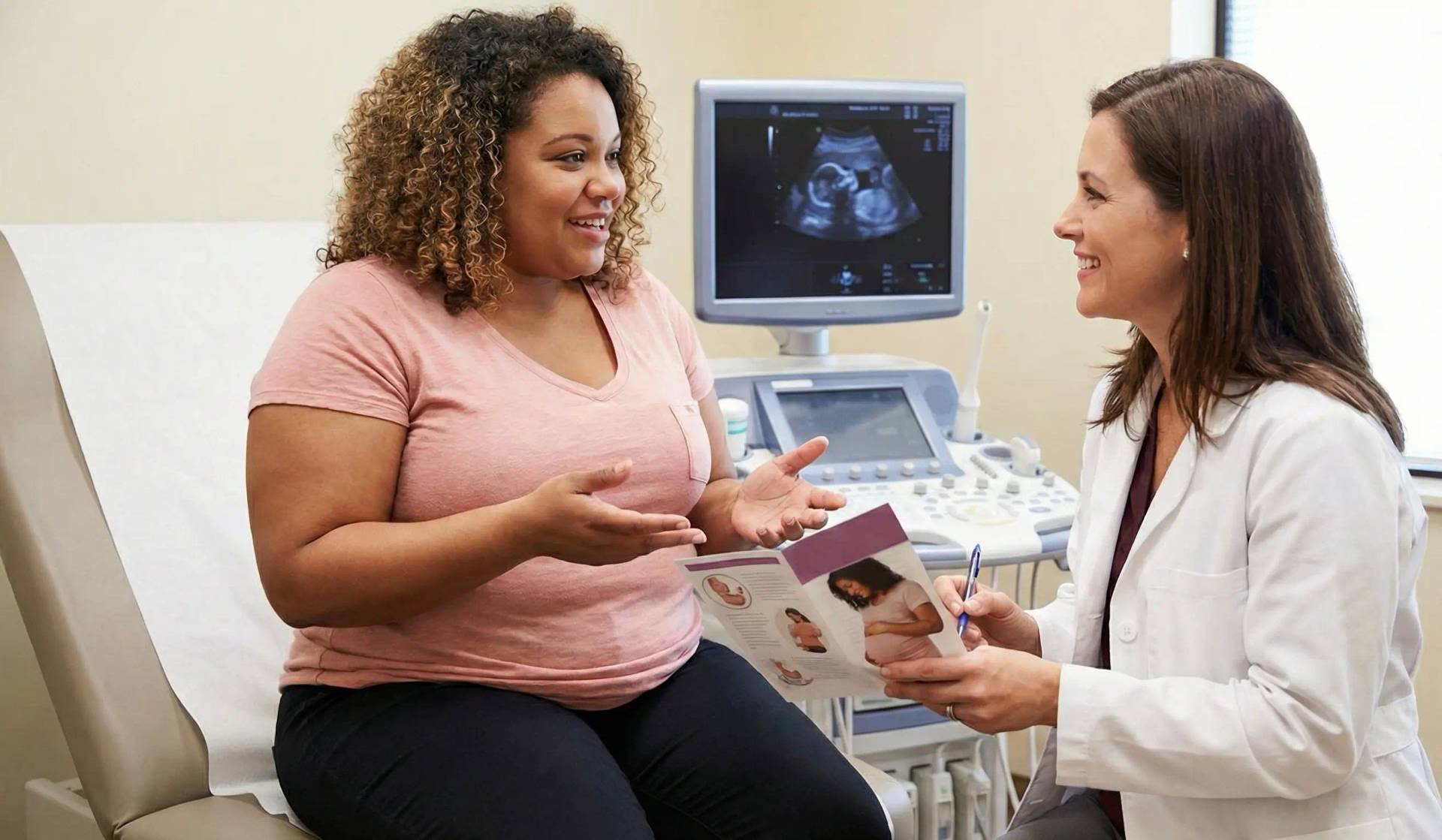 Femme au ventre arrondi discutant avec une professionnelle près d’un échographe.