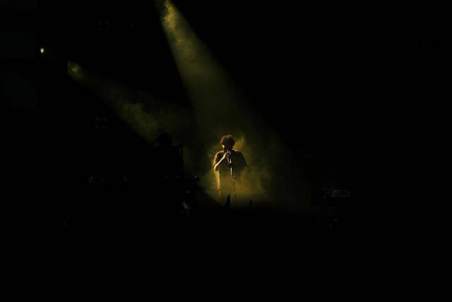 Scène de concert captivante mettant en vedette un joueur de flûte sous un éclairage de scène dramatique
