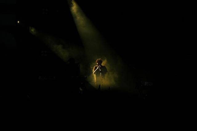 Scène de concert captivante mettant en vedette un joueur de flûte sous un éclairage de scène dramatique