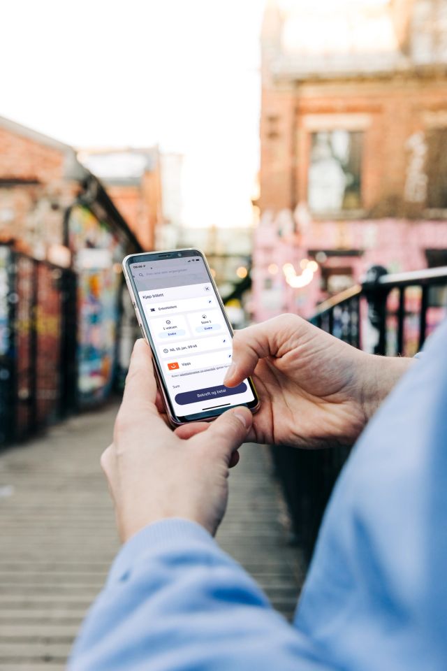 Person sjekker billetten på telefonen sin
