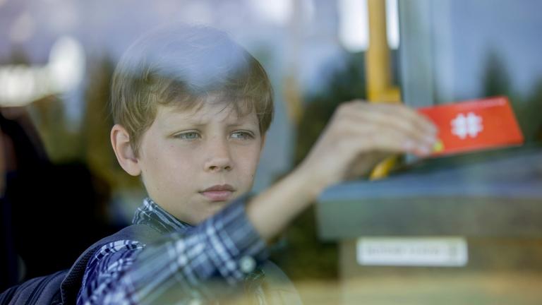 gutt bruker skolekortet på bussen på vei til skolen