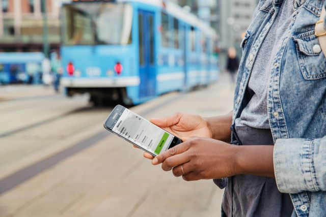 Kvinne holder telefon med enkeltbillett
