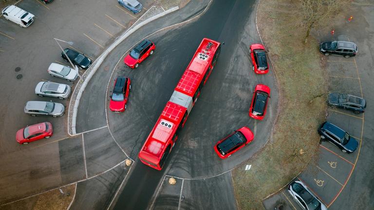 Buss som står parkert med Selvkjørende biler rundt.