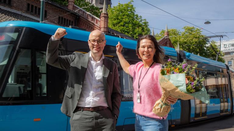Ruter og Noregs Mållag feirer foran trikken at Ruter-appen er på nynorsk