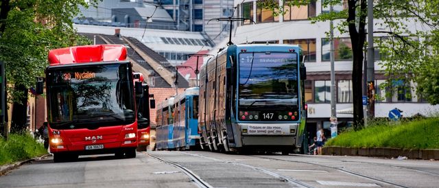 A red bus and a blue tramway in service