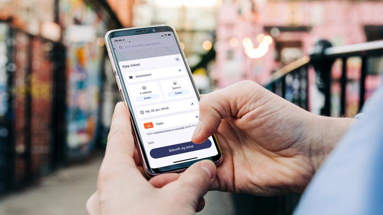 Person sjekker billetten på telefonen sin