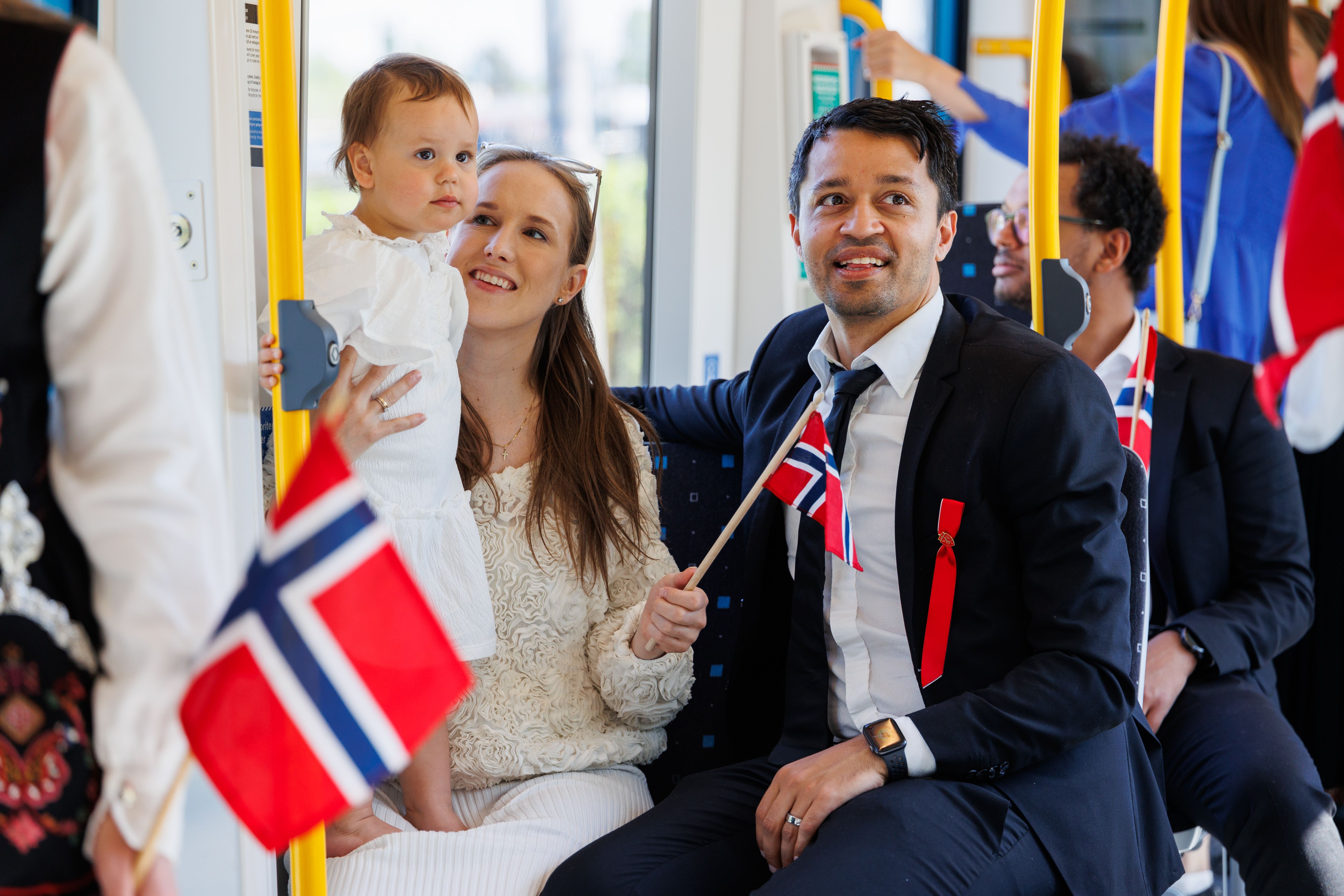 A family is taken the metro on 17th may. Many Norwegian flags