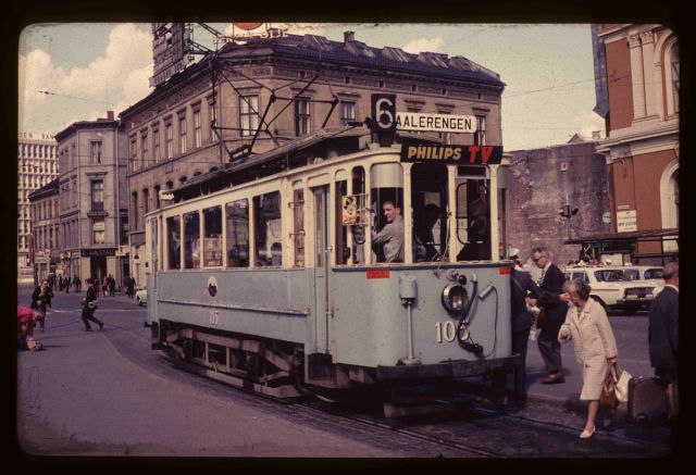A picture from the late 1960s, showing people on board an old tram in the city centre of Oslo.