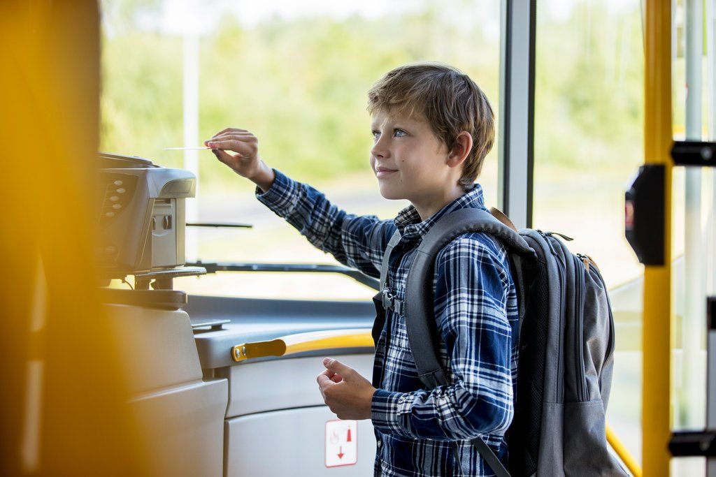 Gutt validerer reisekort på bussen