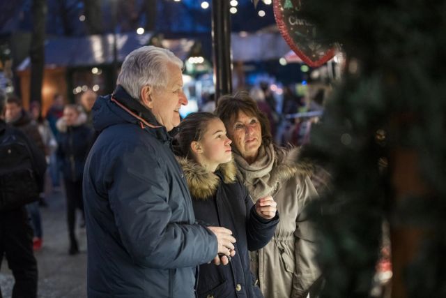 Bilde av to voksne og et barn på julemarked