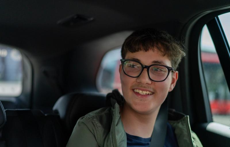 Et nærbilde av en ung mann inni i en bil