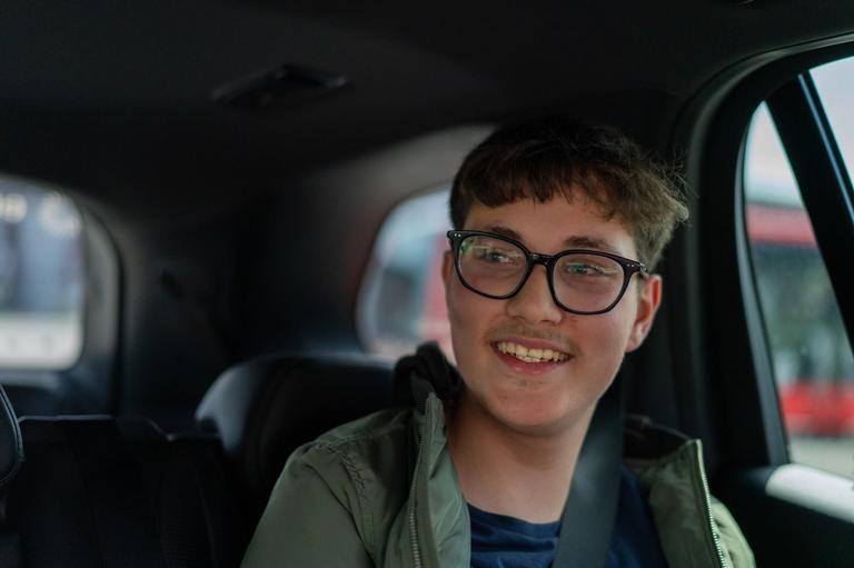 Et nærbilde av en ung mann inni i en bil