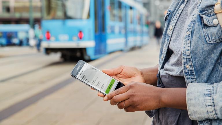 Kvinne holder telefon med enkeltbillett
