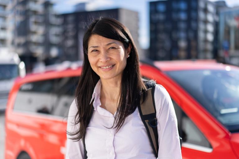 Kvinne foran en rød bil