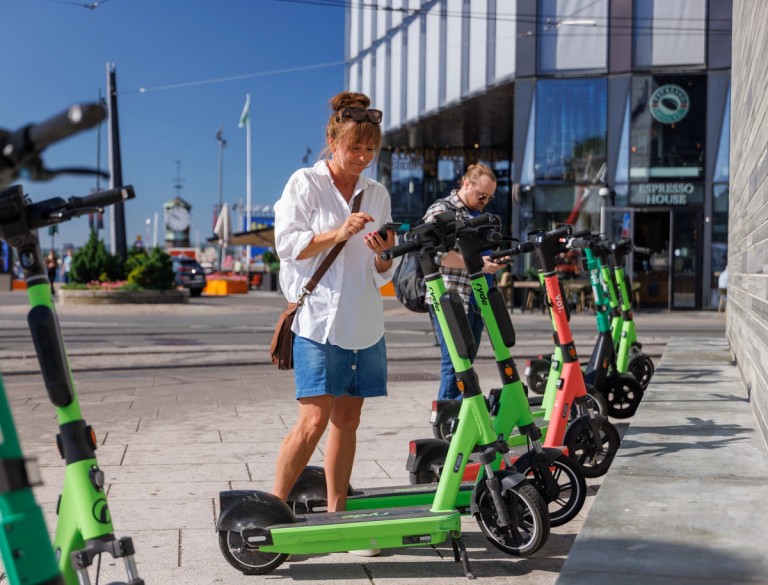 A woman rents a electric scooter in oslo