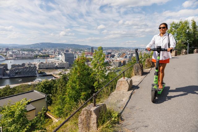 En kvinne kjører elsykkel nedover bakken