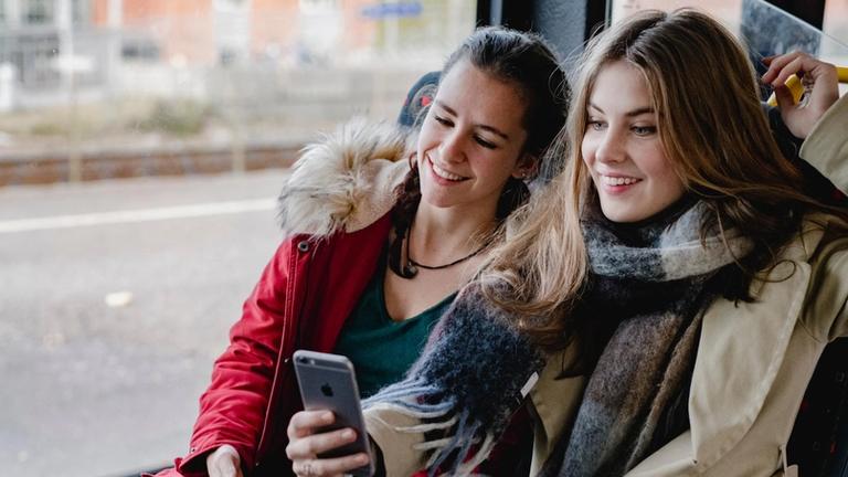 Bilde av to smilende ungdomsjenter på buss