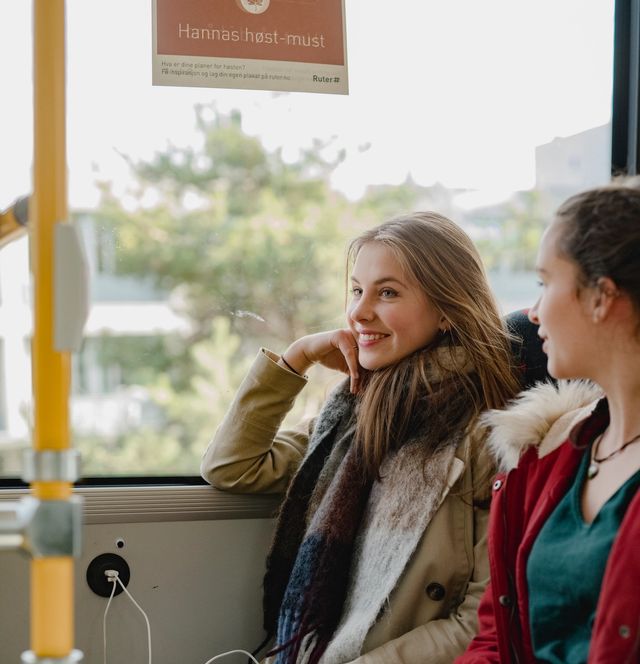 To tenåringsjenter sitter på en buss