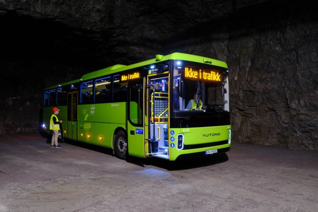 Picture of a green bus inside a mountain environment