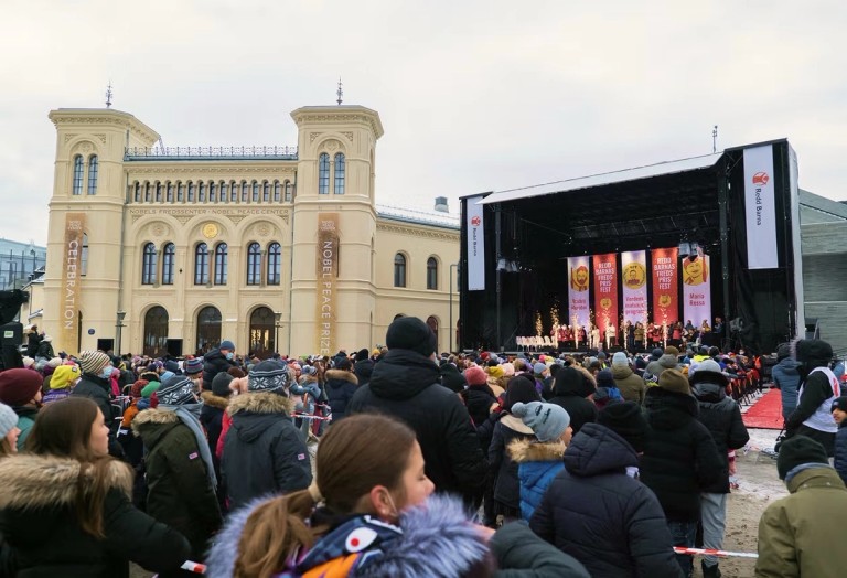 Picture of people in front of a stage at Nobel's Peace Center