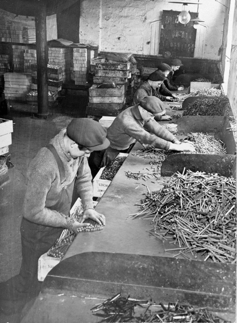 Black and white picture of boys sorting nails