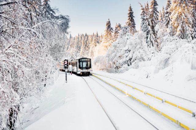 Bilde av en T-banevogn som kjører med snø i omgivelsene