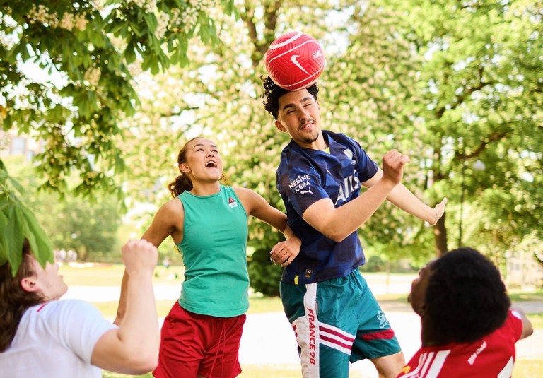 Young adults playing with a ball in a park