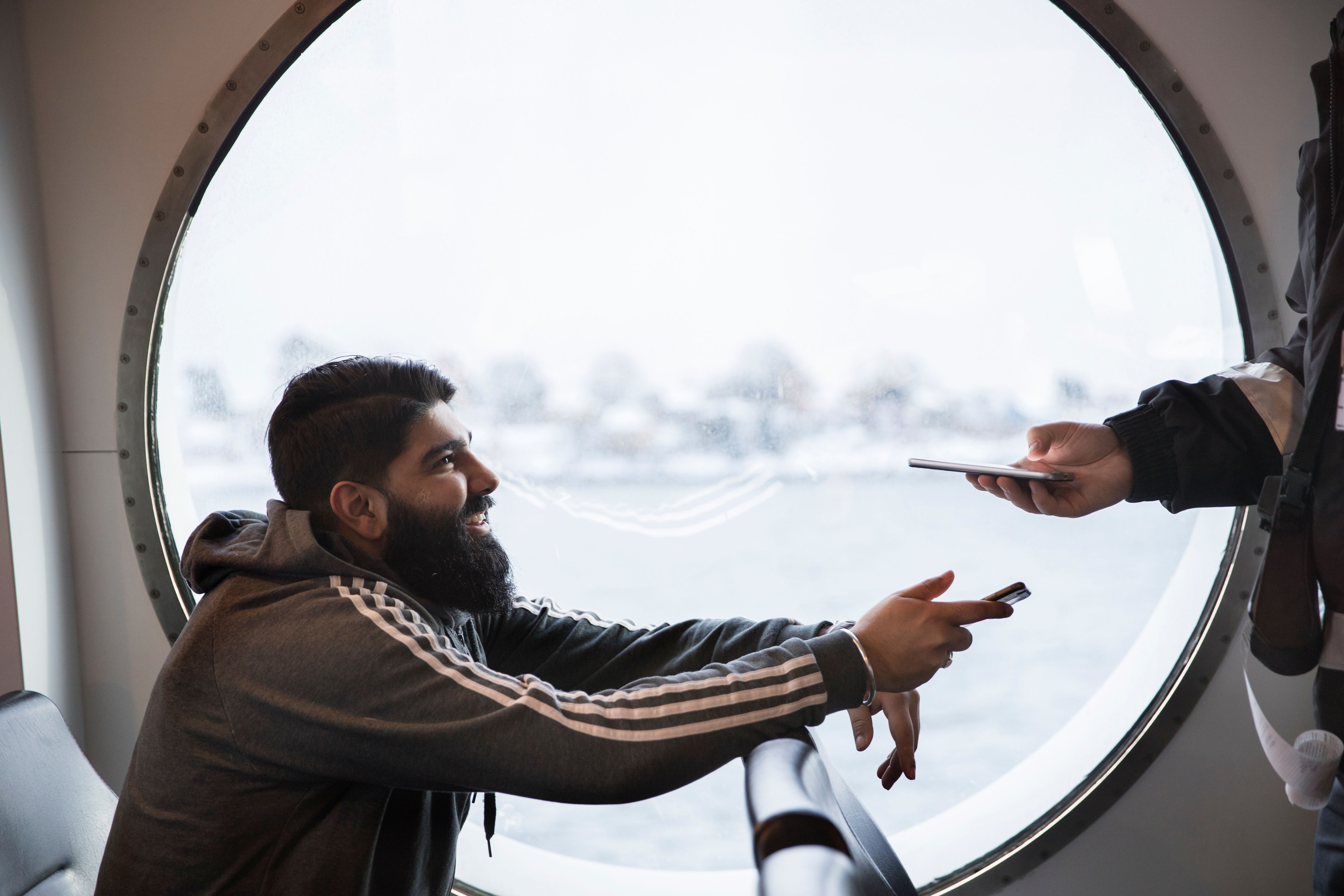 Mann viser billetten sin til kontrollør om bord på båt