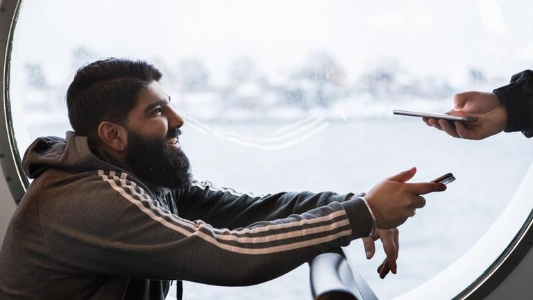 Man showing his ticket to a controller on board a boat