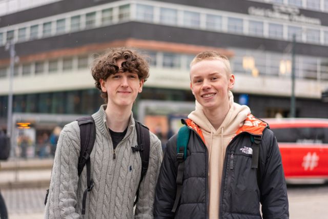 To persjoner smilende på et buss stopp