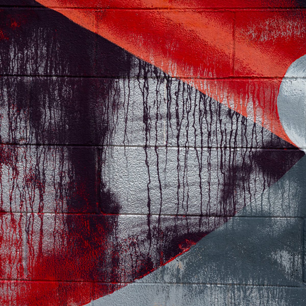 A red diagonal sweeps across grey blocks, with dark crimson drips running down beneath it toward a pale curve.