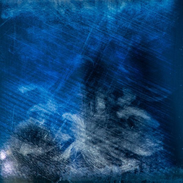 A deep blue surface scratched with fine white lines, with pale swirling marks gathering near the bottom.