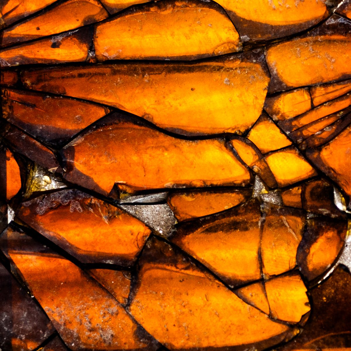 Glowing amber pieces crowd together, each one outlined by a dark crack.