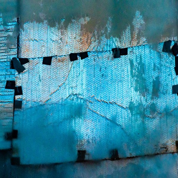 Pale turquoise textured panels with torn, peeling edges, held by small dark squares along a jagged seam.