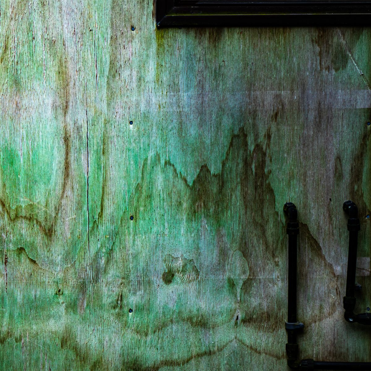 Washes of mint green and moss stain drift across a pale streaked surface, with two dark L-shaped forms at the right.