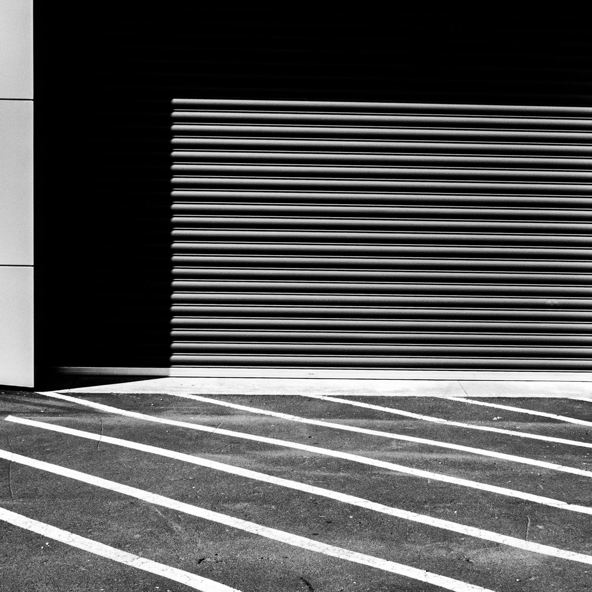 A block of fine horizontal lines sits in deep black, above white diagonal stripes across a grey ground.