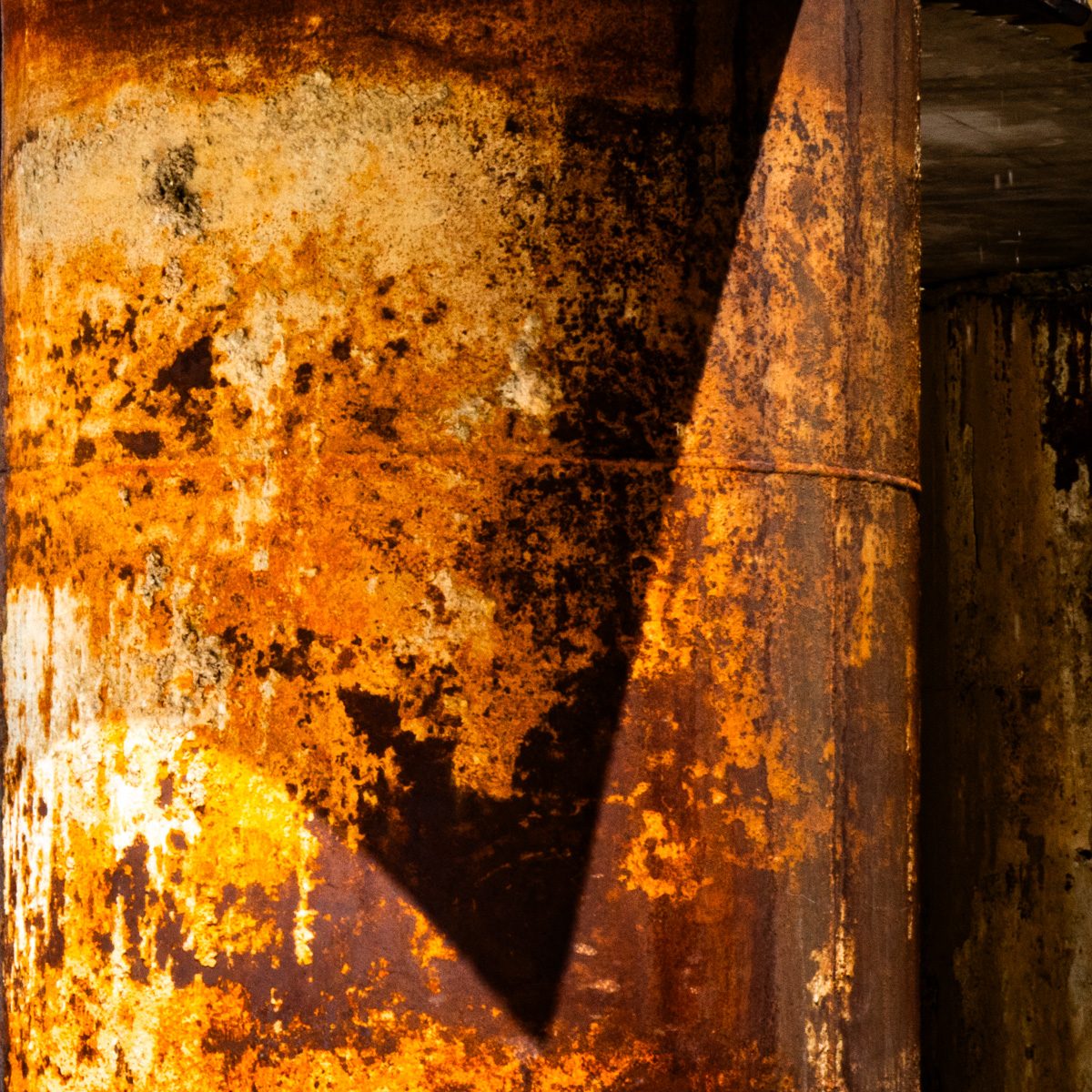 Mottled, streaked surfaces of orange and black, with a sharp black triangle cutting diagonally through the middle.