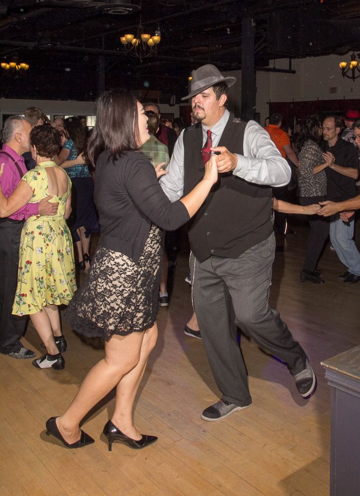Couples swing dancing to the SwingMasters on a crowded dance floor