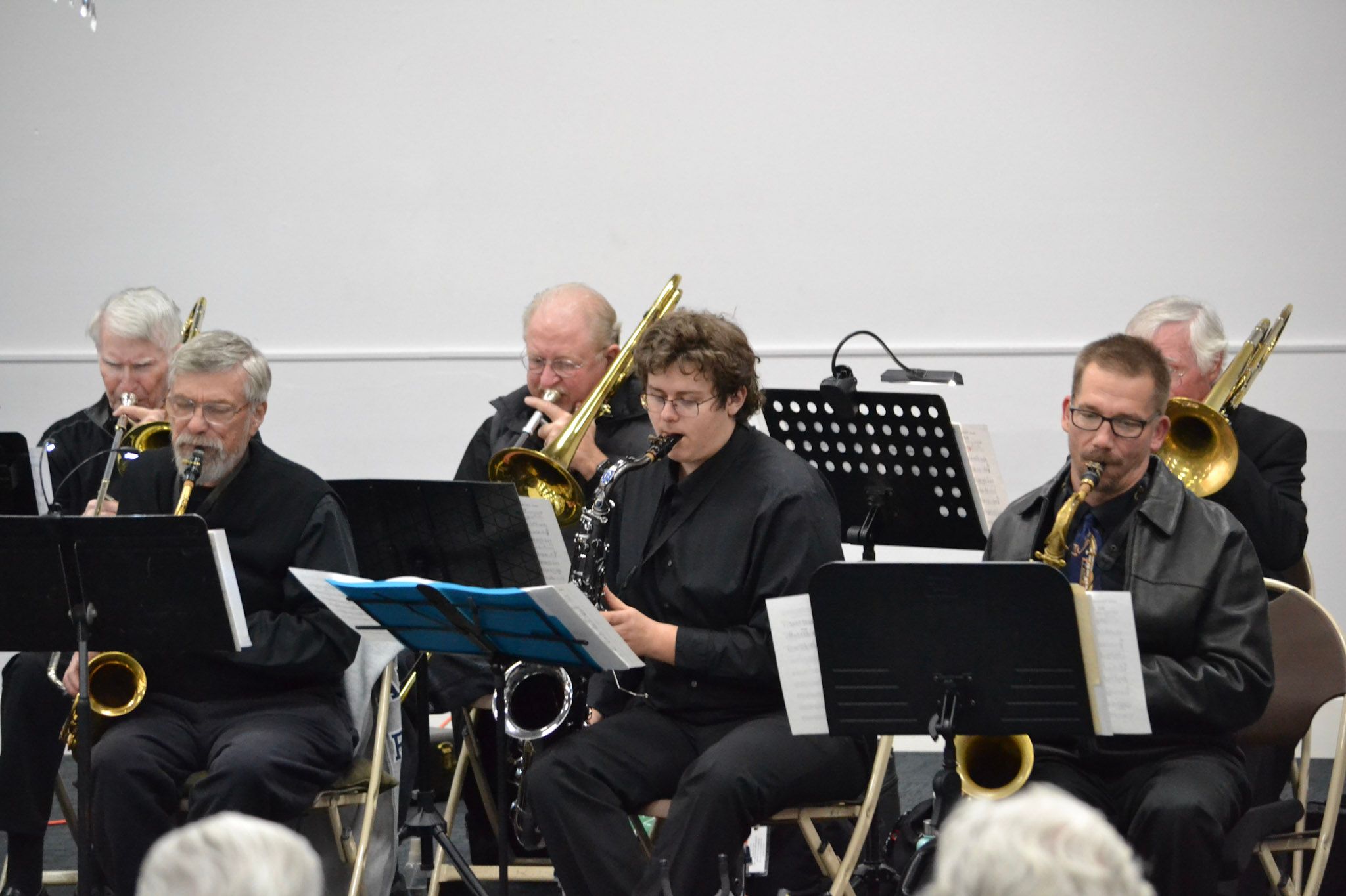 Saxophone and trombone players performing side by side