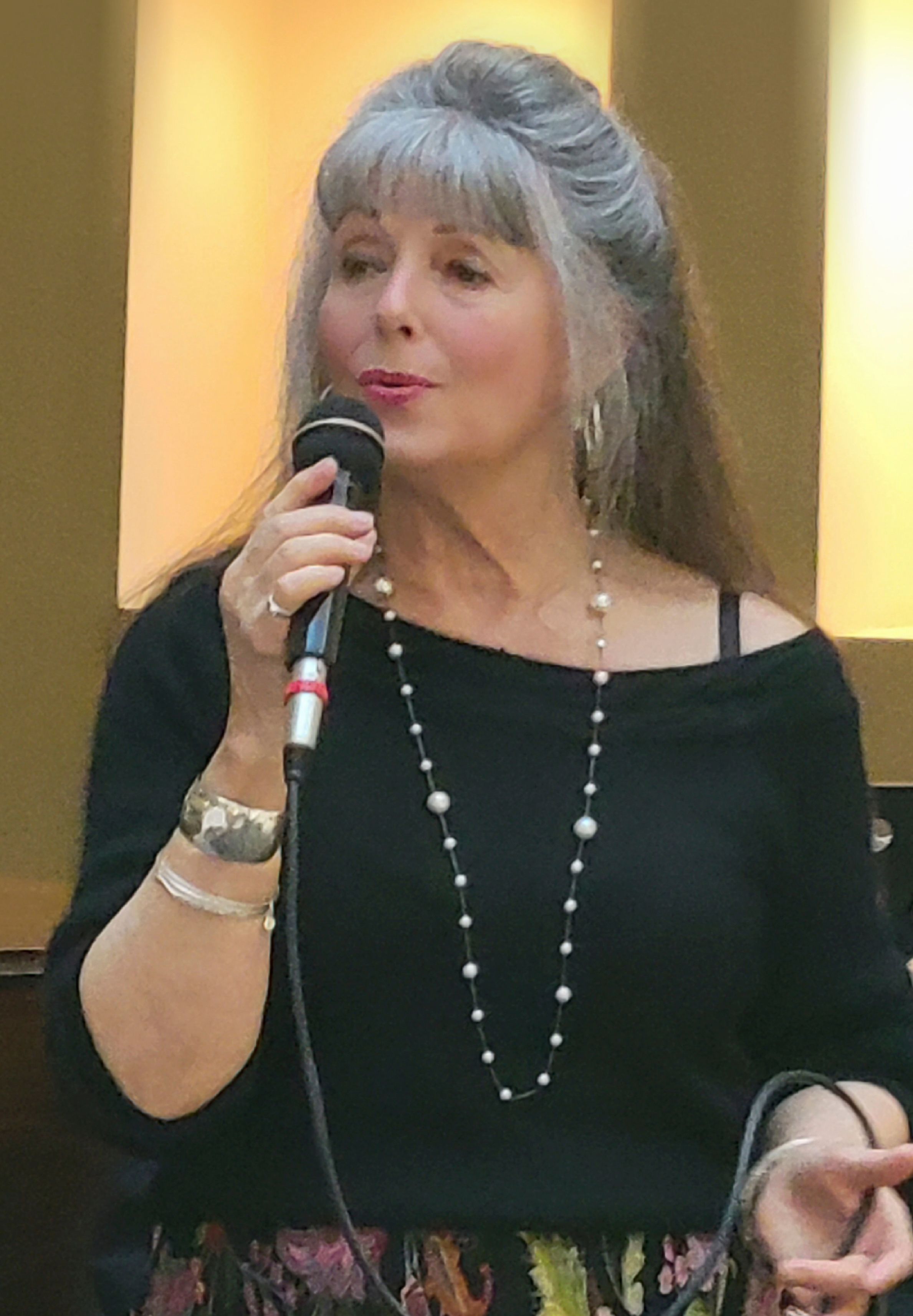 Rubi singing into a handheld microphone